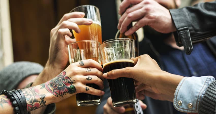 Closeup of people's hands toasting a beer