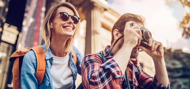 two travelers with sunglasses take in scenery and take pictures