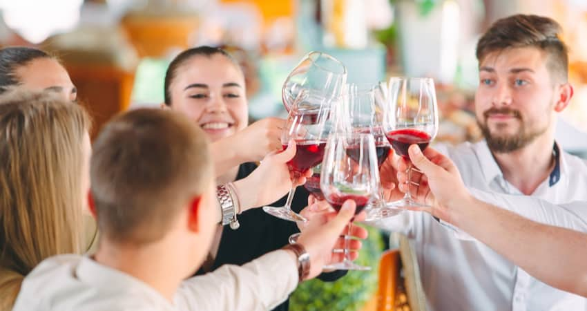 Friends toasting wine at a patio restaurant