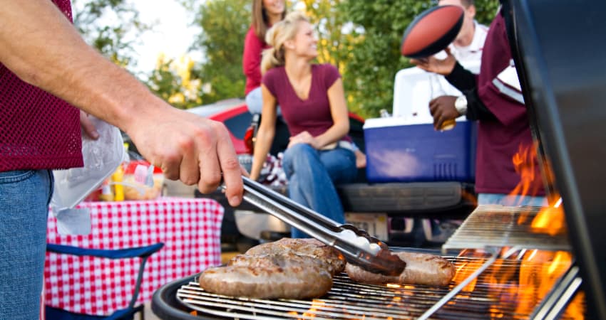 A group of fans tailgate outside a football game