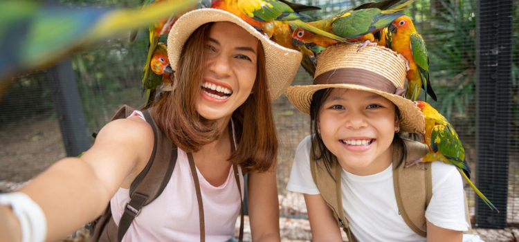 a woman and young girl surrounded by birds and smiling